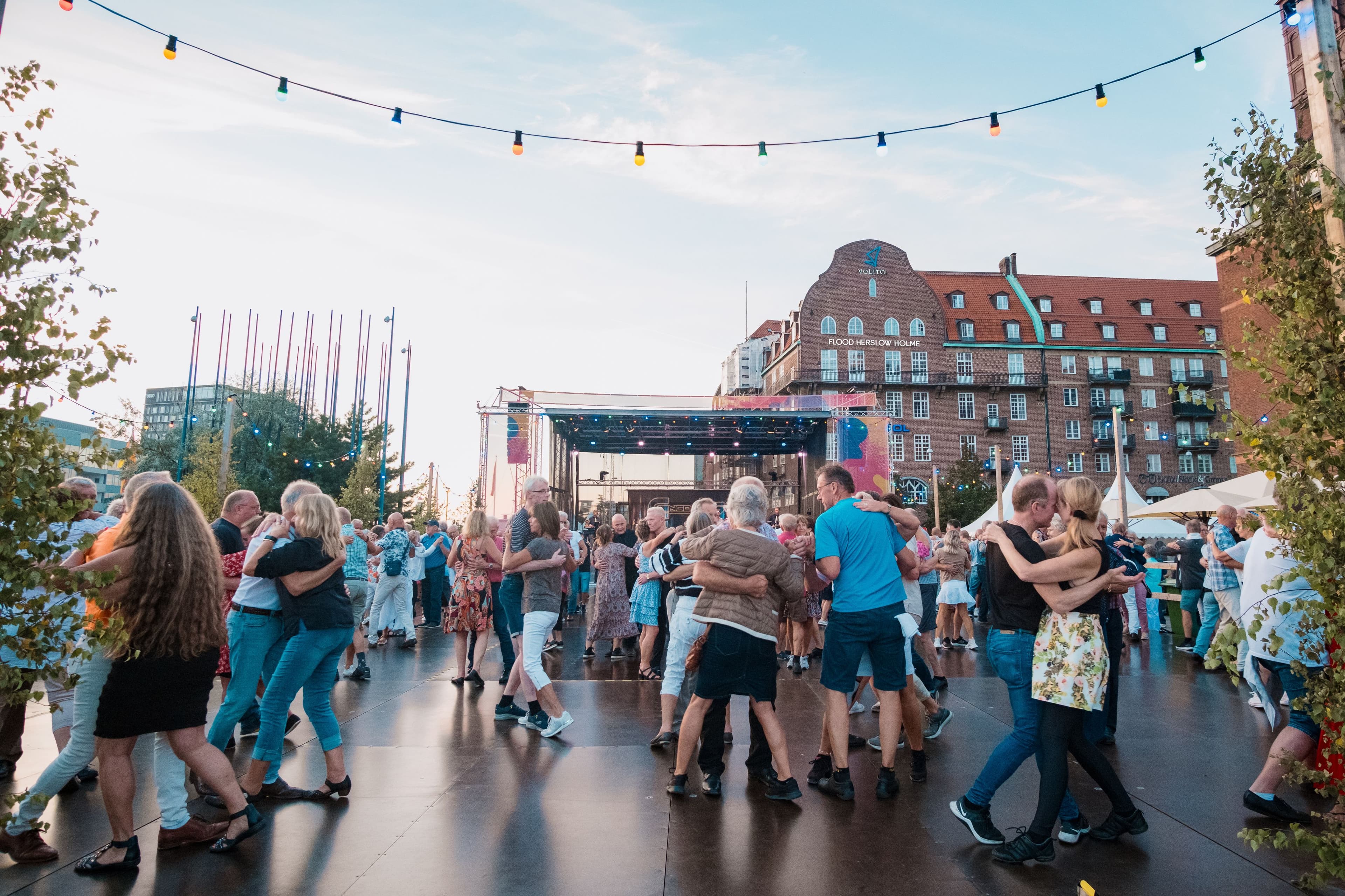 Människor dansar i par på ett dansgolv utomhus i stadsmiljö under Malmöfestivalen.
