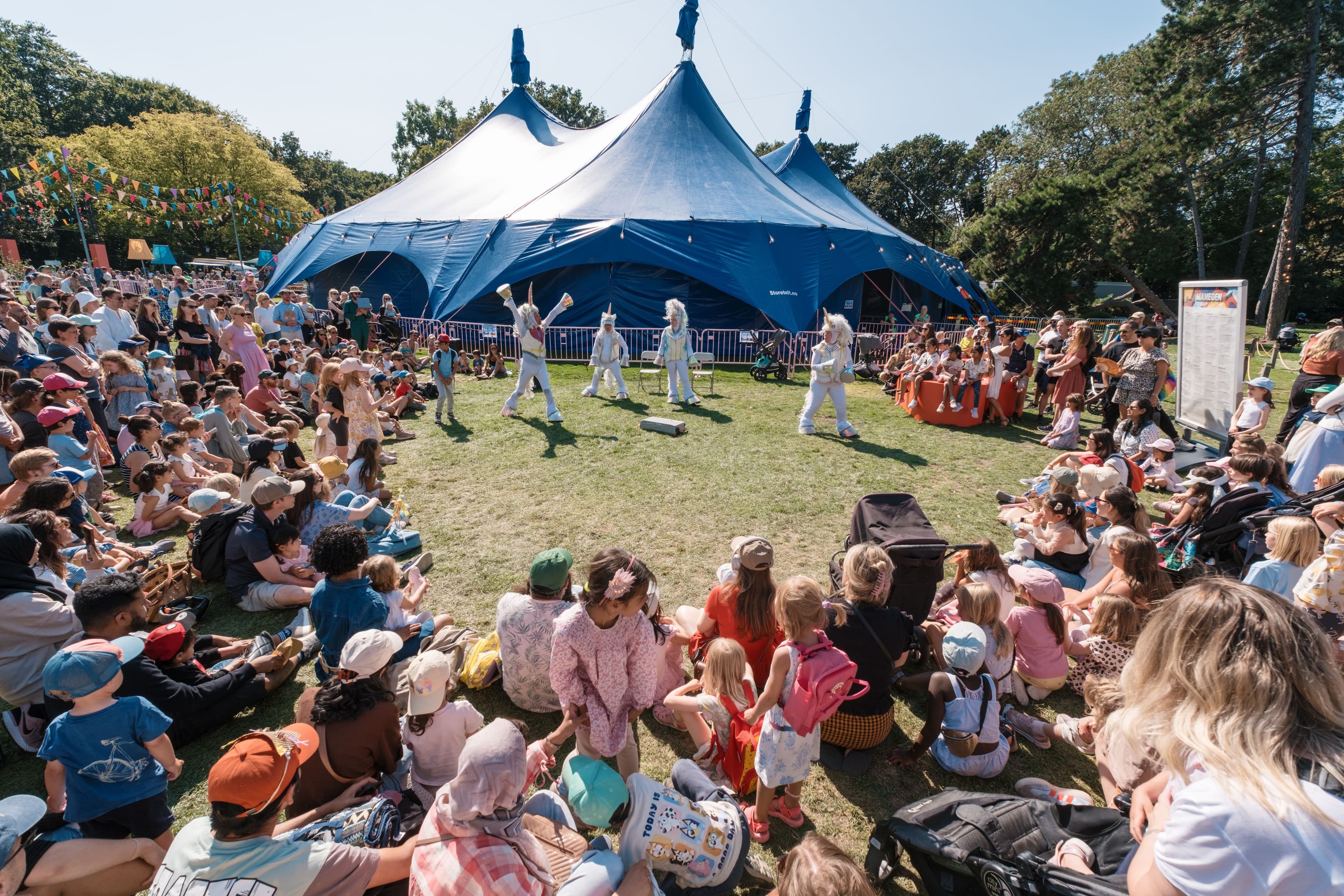 Stor publik samlad runt en utomhusscen i en park under ett uppträdande på Malmöfestivalen.