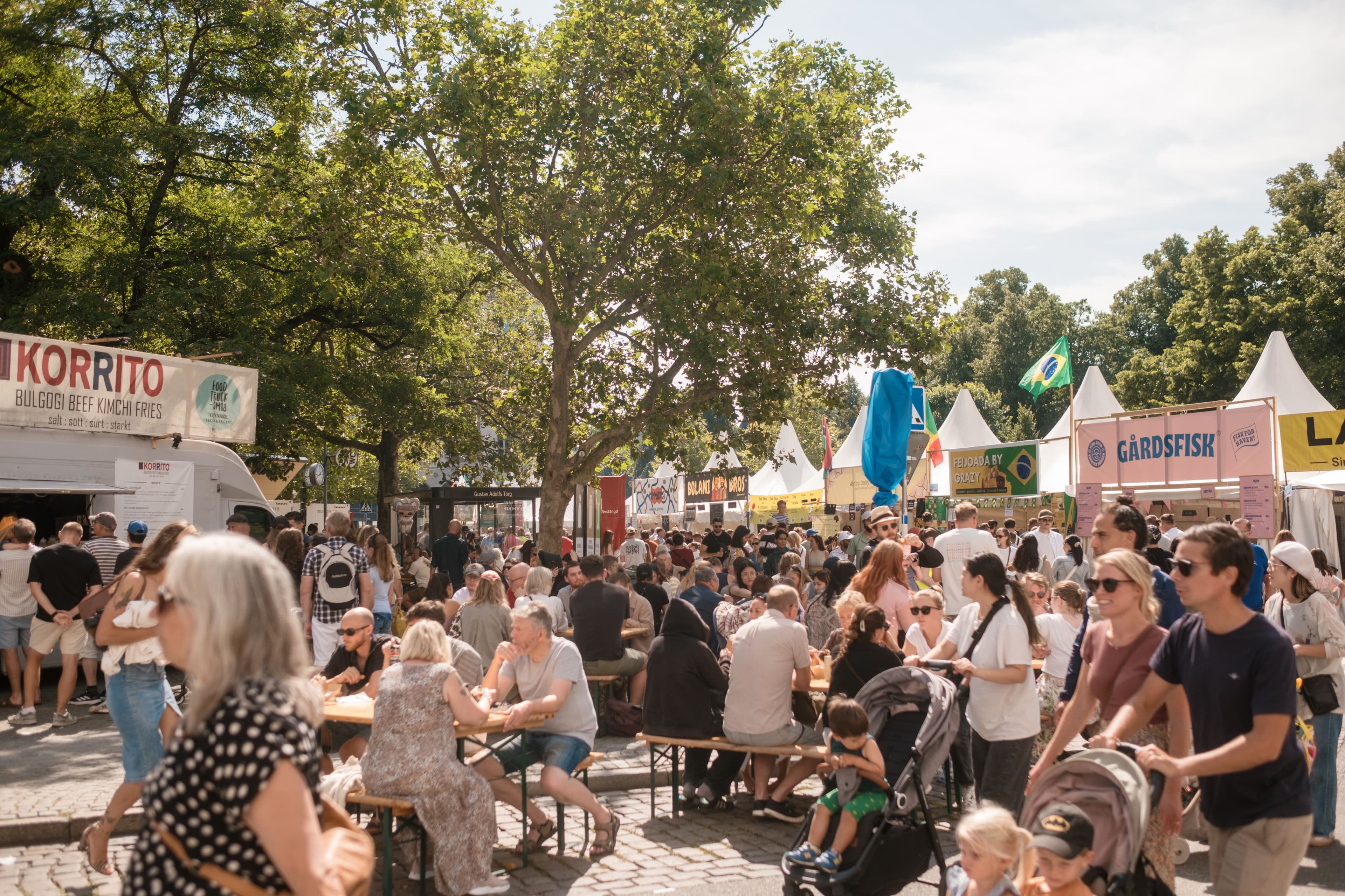 Mycket folk som äter eller rör sig på matområdet på Malmöfestivalen.